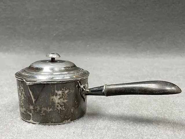 Silver ladle with a wooden handle that has been blackened. 
Marks...