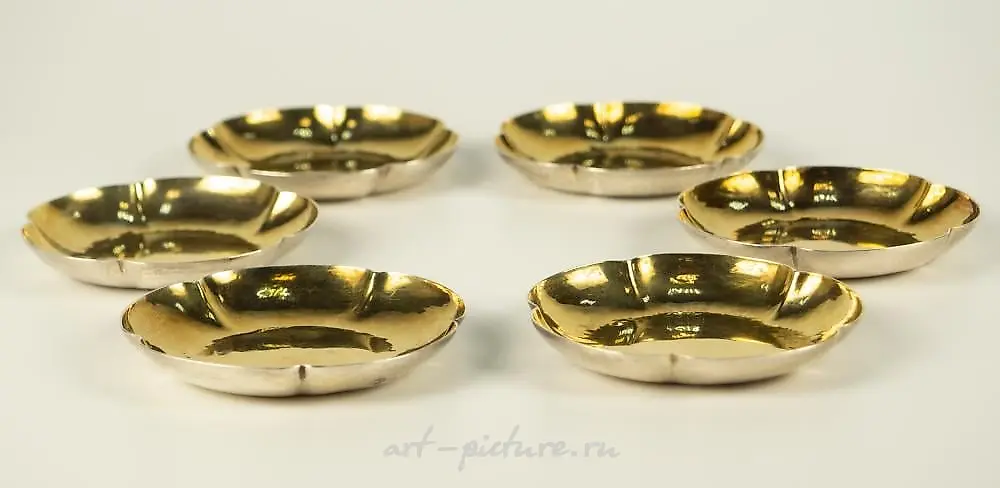 6 small silver bowls with curly edges.