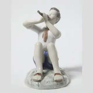 Porcelain figurine of a Boy Playing the Flute by Bing Grondahl.