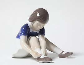 "Girl fastening her shoe. Denmark, Copenhagen, Bing & Grondahl."