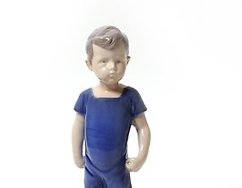 "Kai. A standing boy in shorts. Denmark, Copenhagen, Bing & Grondahl."
