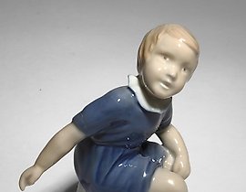 女孩坐在长椅上。丹麦，哥本哈根，Bing & Grondahl