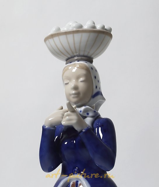 A woman with a basket of eggs on her head. Denmark, Copenhagen, Royal Copenhagen.