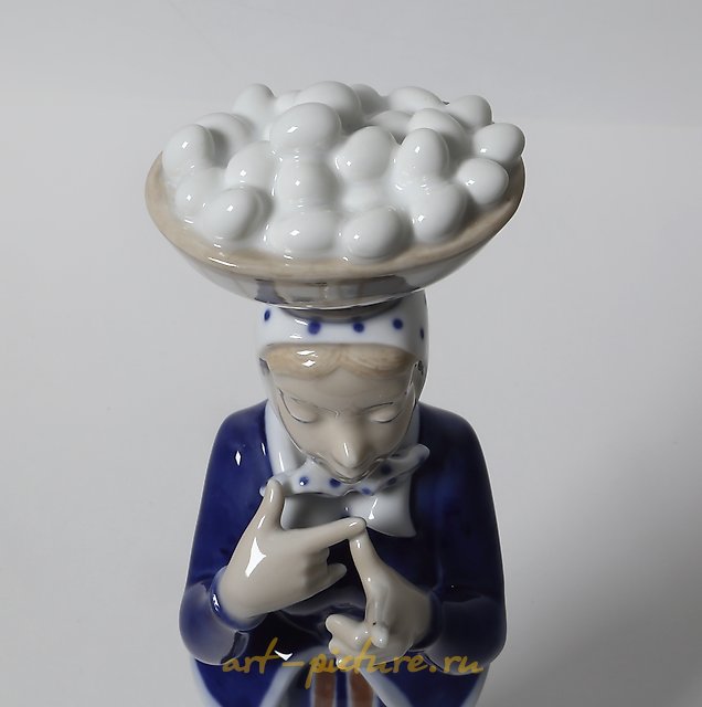 A woman with a basket of eggs on her head. Denmark, Copenhagen, Royal Copenhagen.