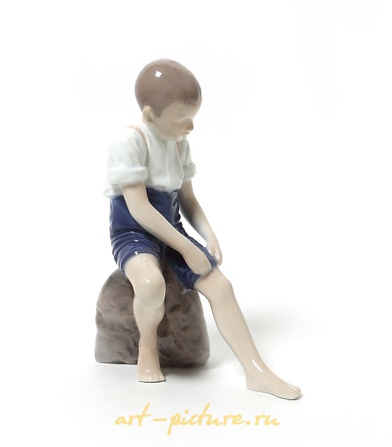 "Boy rolling up his pant leg. Denmark, Copenhagen, Bing & Grondahl."
