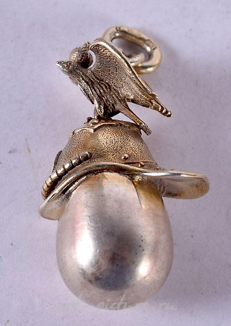 A SILVER EGG PENDANT WITH AN EAGLE SITTING ON A HELMET CLASP...
