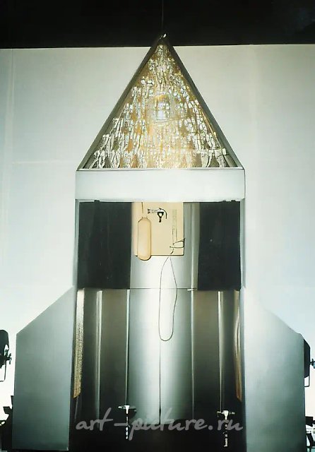 祷告机，1992年，金属、木材、玻璃，200×150×60厘米。NSK（新斯洛文尼亚艺术）“努尔杜恩”剧院舞台设计的一部分，斯洛文尼亚卢布尔雅那。