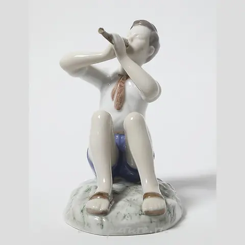 Porcelain figurine of a Boy Playing the Flute by Bing Grondahl.