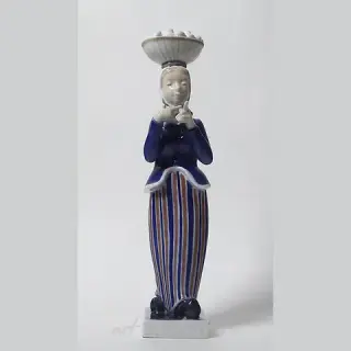 A woman with a basket of eggs on her head. Denmark, Copenhagen, Royal Copenhagen.