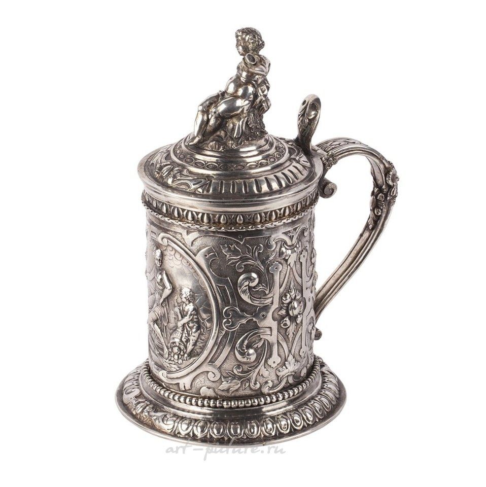 Russian silver , A Russian baroque cast silver-gilt mug with a lid crowned by...