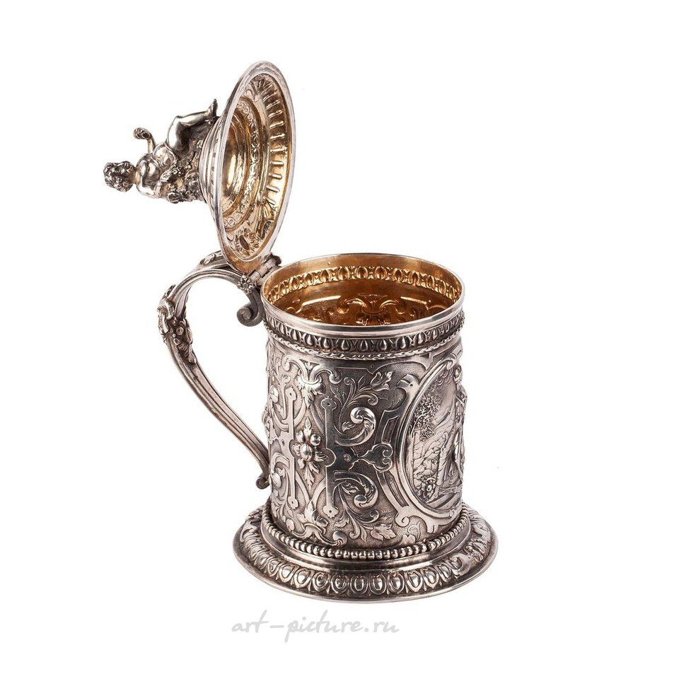 Russian silver , A Russian baroque cast silver-gilt mug with a lid crowned by...