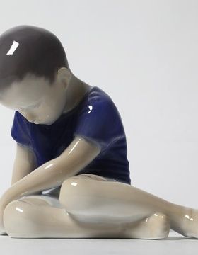 buy The boy sitting with his head down.
